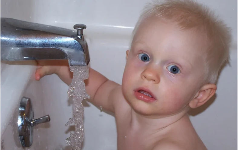 Toddler curious about running water